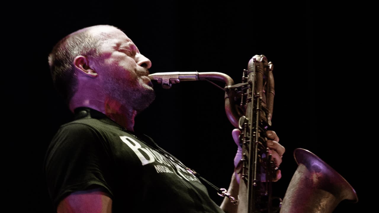 A person passionately playing a saxophone on stage.